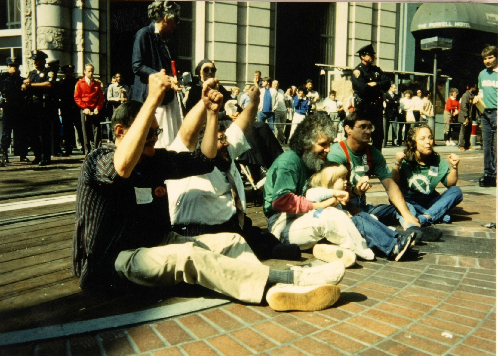 Protesters in green T-shirts block the turnaround of a cable car.